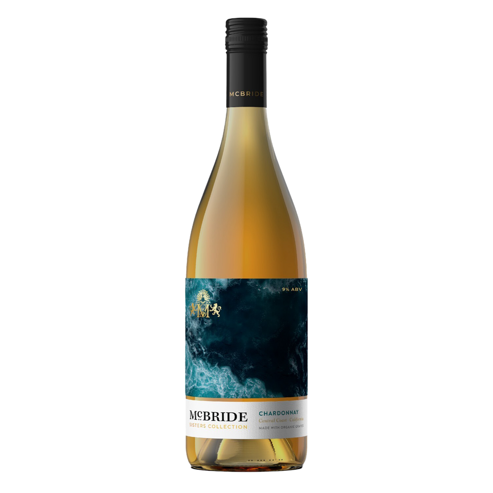 A bottle of McBride Sisters Collection Chardonnay stands upright against a transparent background. The wine features a sleek design with a dark blue and gold label, showcasing the brand name and product details prominently.