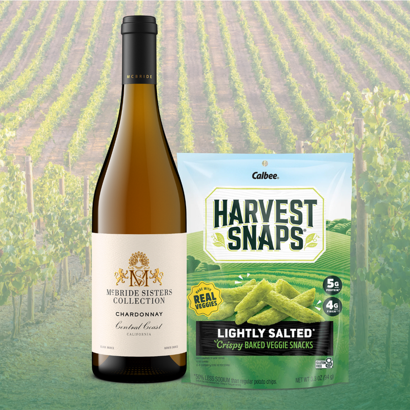 Mcbride Sisters Chardonnay wine bottle next to a bag of Harvest Snaps Lightly Salted flavor. 