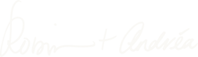 A very light gray cursive script reading 'Robin + Andreá' on a white background.