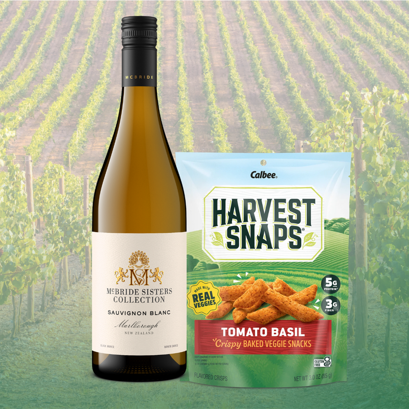 Mcbride Sisters Sauvignon Blanc wine bottle next to a bag of Harvest Snaps Tomato Basil flavor. 